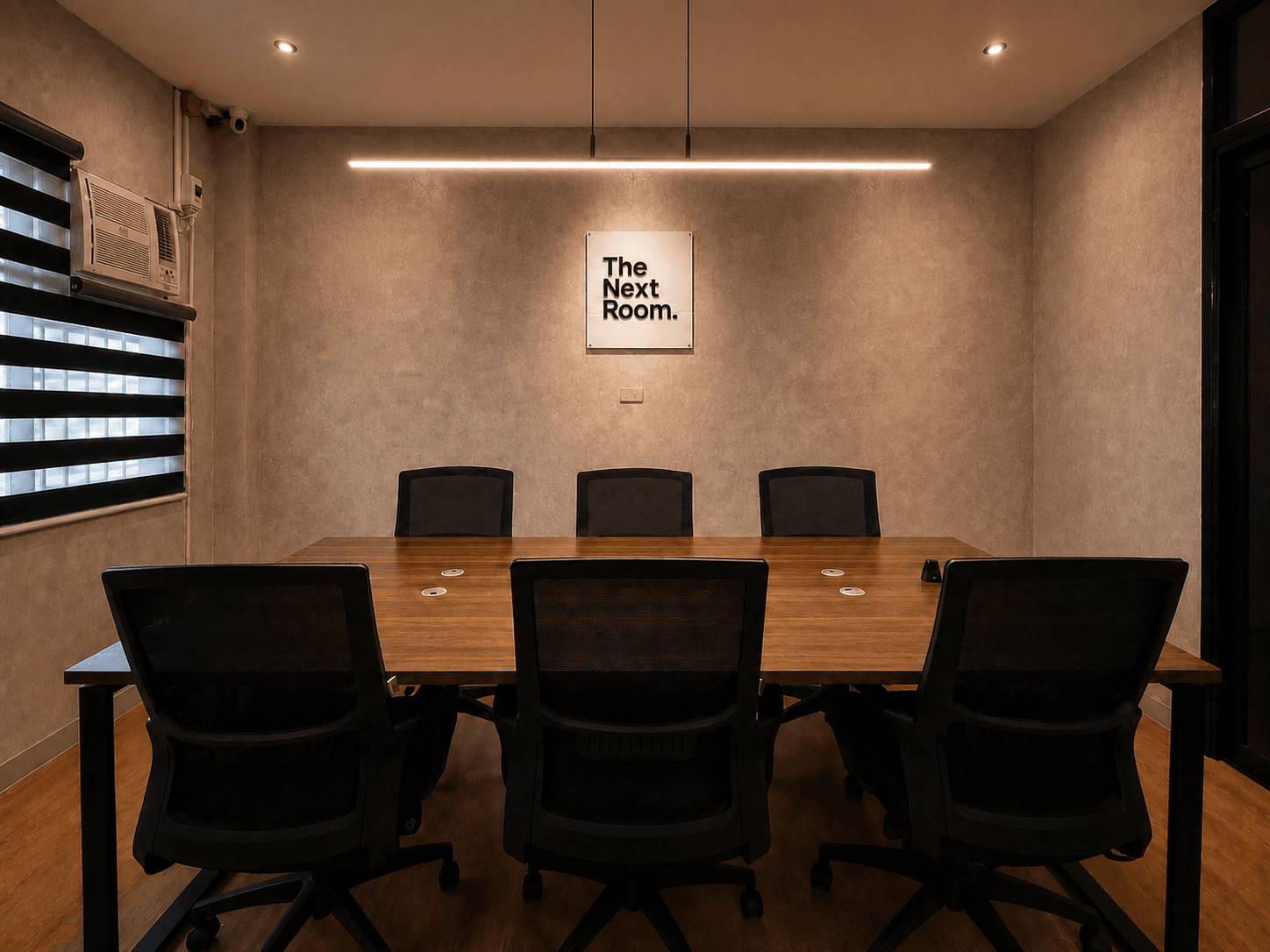 Front view of The Next Room meeting table with seating for six to eight people.